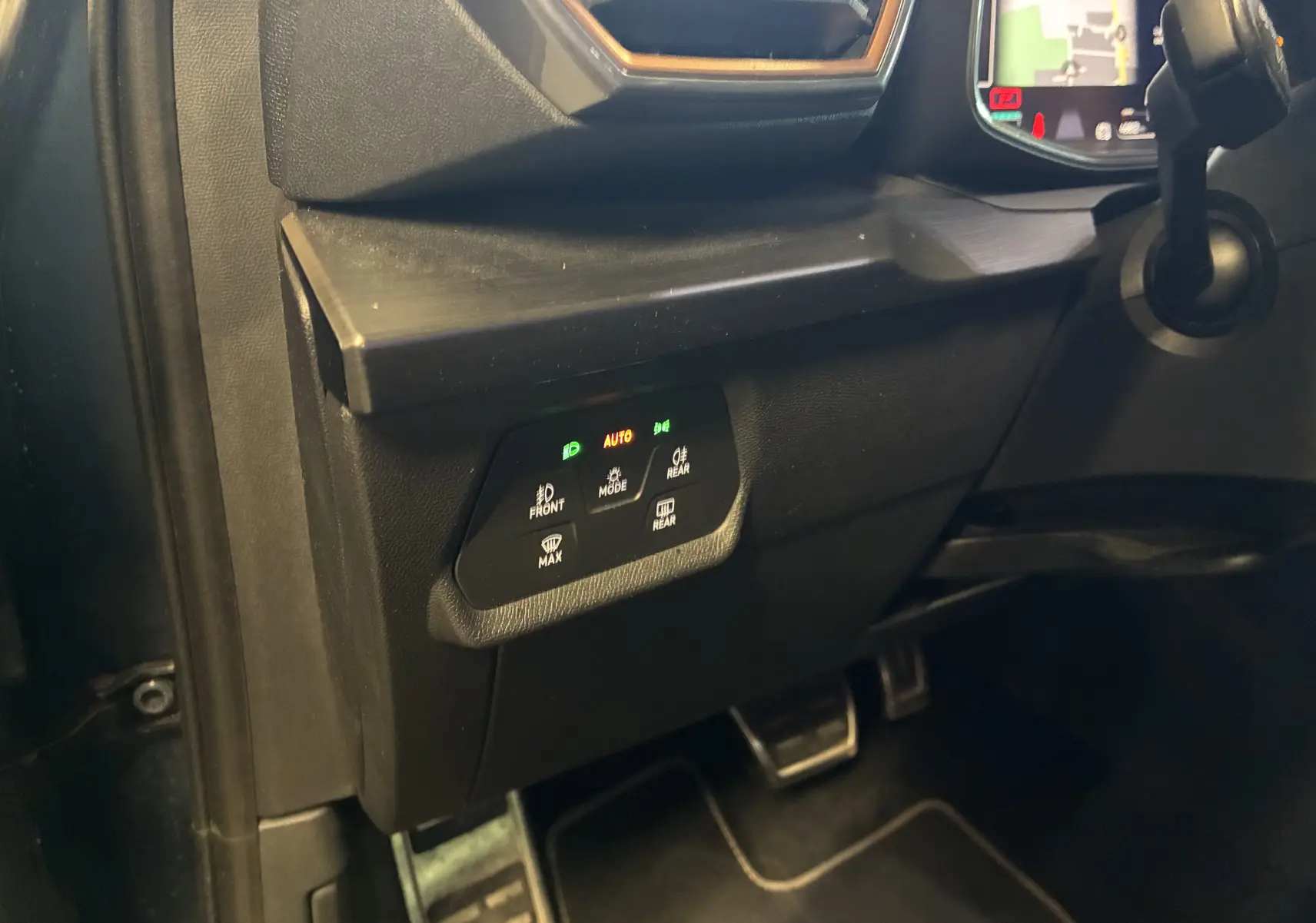 Vue intérieure côté gauche du tableau de bord noir avec commandes d'éclairage et pédales visibles dans une CUPRA Formentor 2023.
