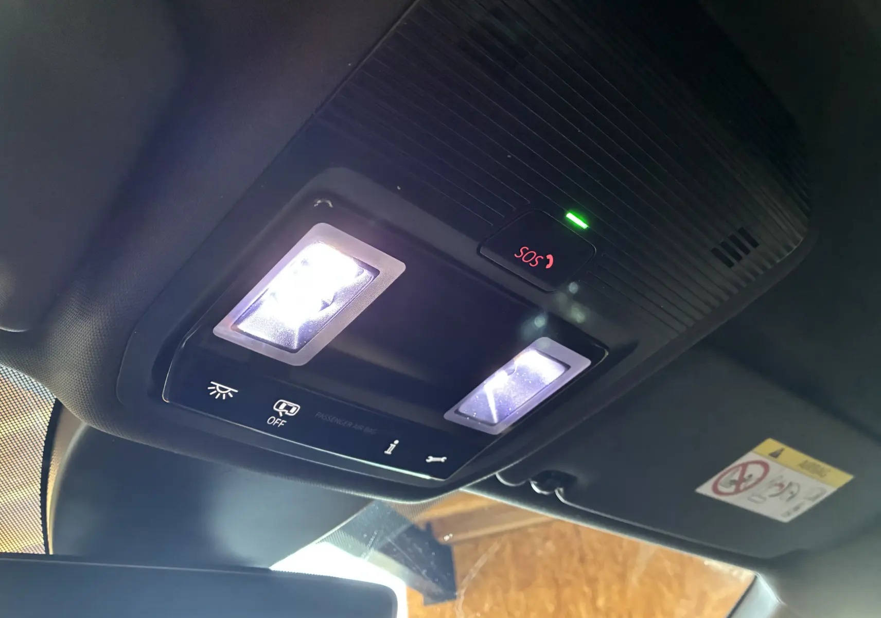 Vue intérieure en contre-plongée du plafonnier noir avec éclairage LED et bouton SOS rouge allumé dans une CUPRA Formentor bleu.