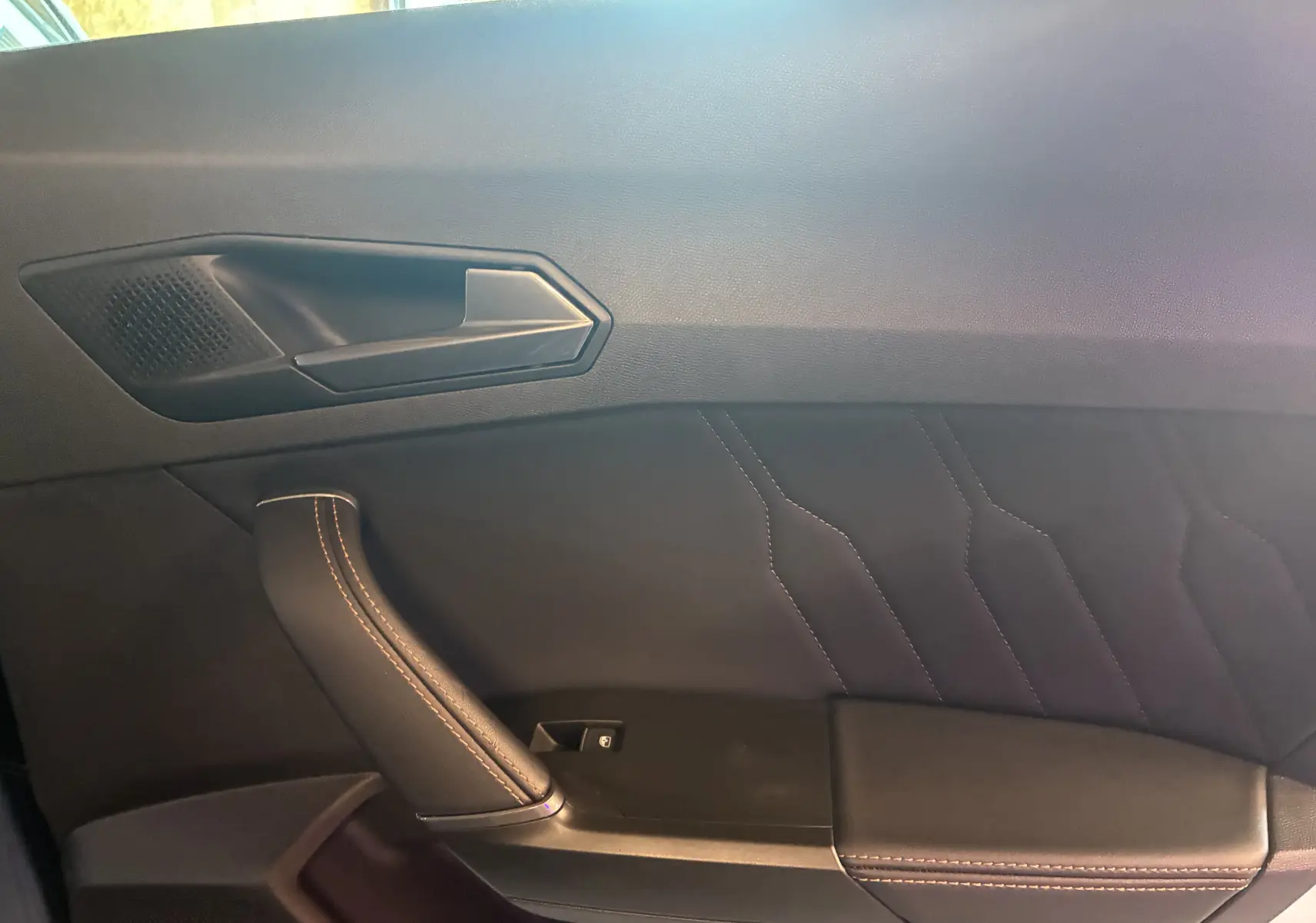 Détail de la porte côté gauche du CUPRA Formentor 1.4 e-Hybrid 2023 avec finition cuir noir et surpiqûres cuivre.