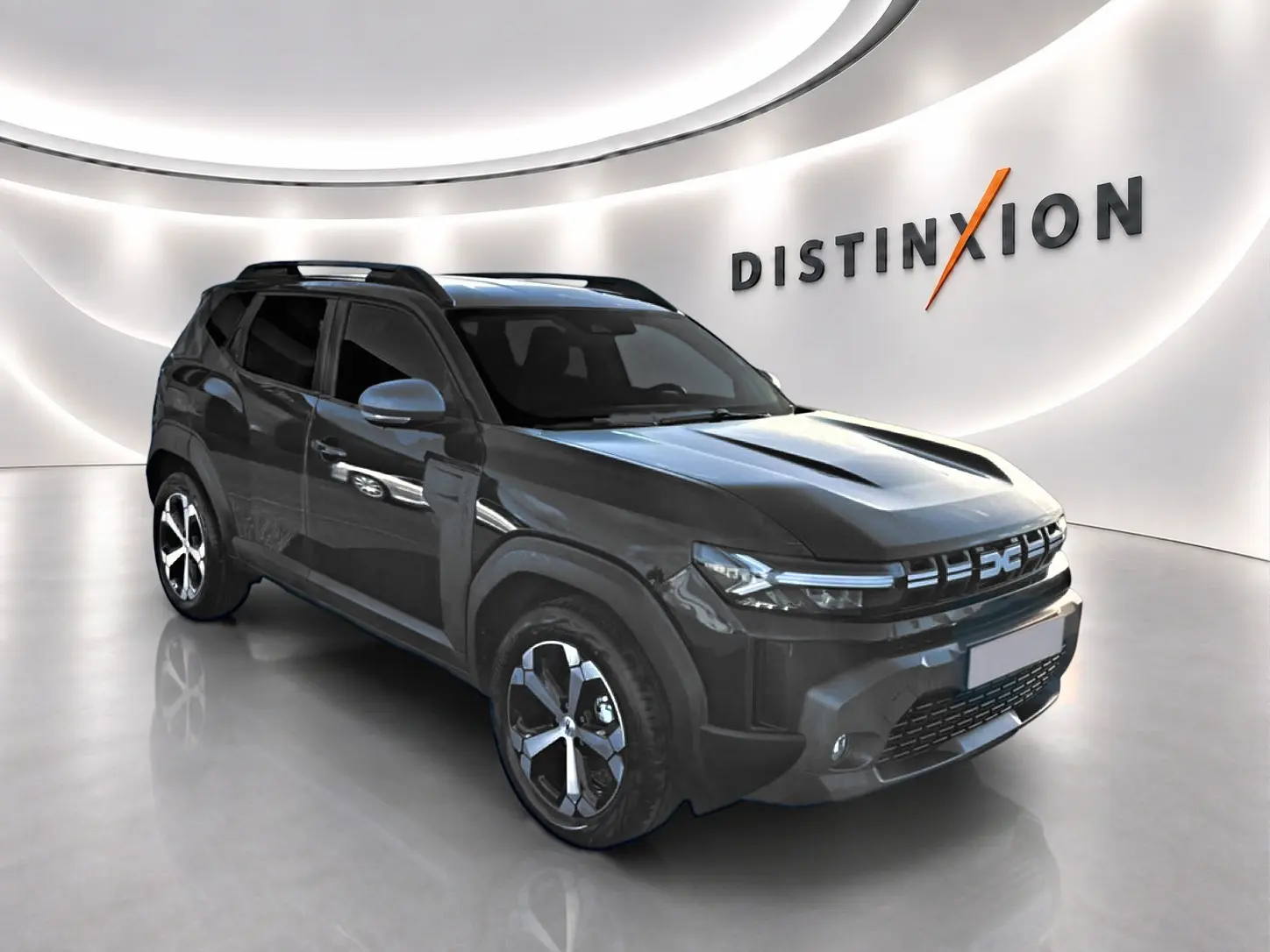 SUV Dacia Duster noir en 3/4 avant droit, avec jantes alliage et barres de toit visibles en showroom lumineux.