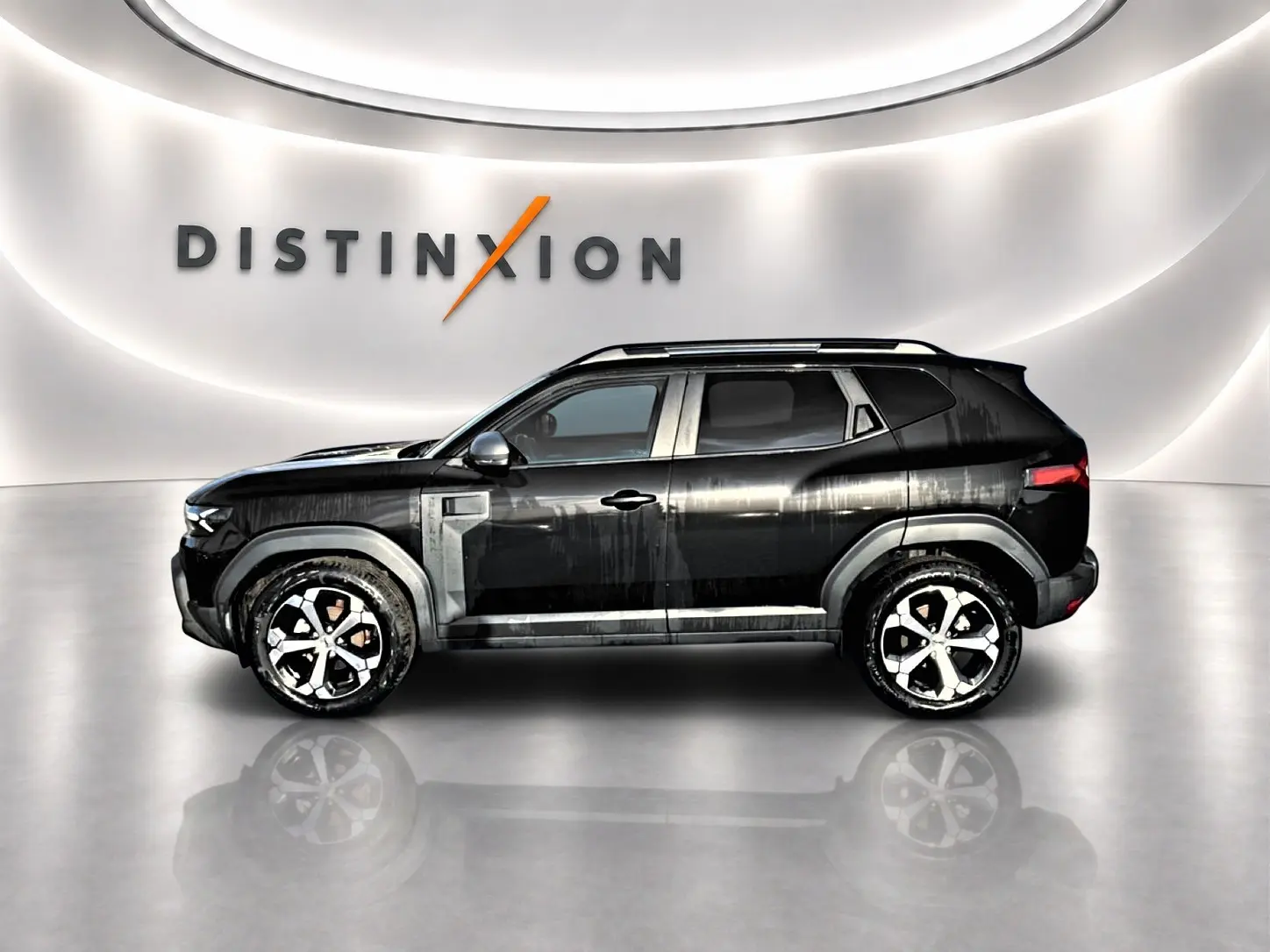 Profil côté gauche du Dacia Duster noir 2026 avec jantes alu et barres de toit, sur fond lumineux intérieur showroom.
