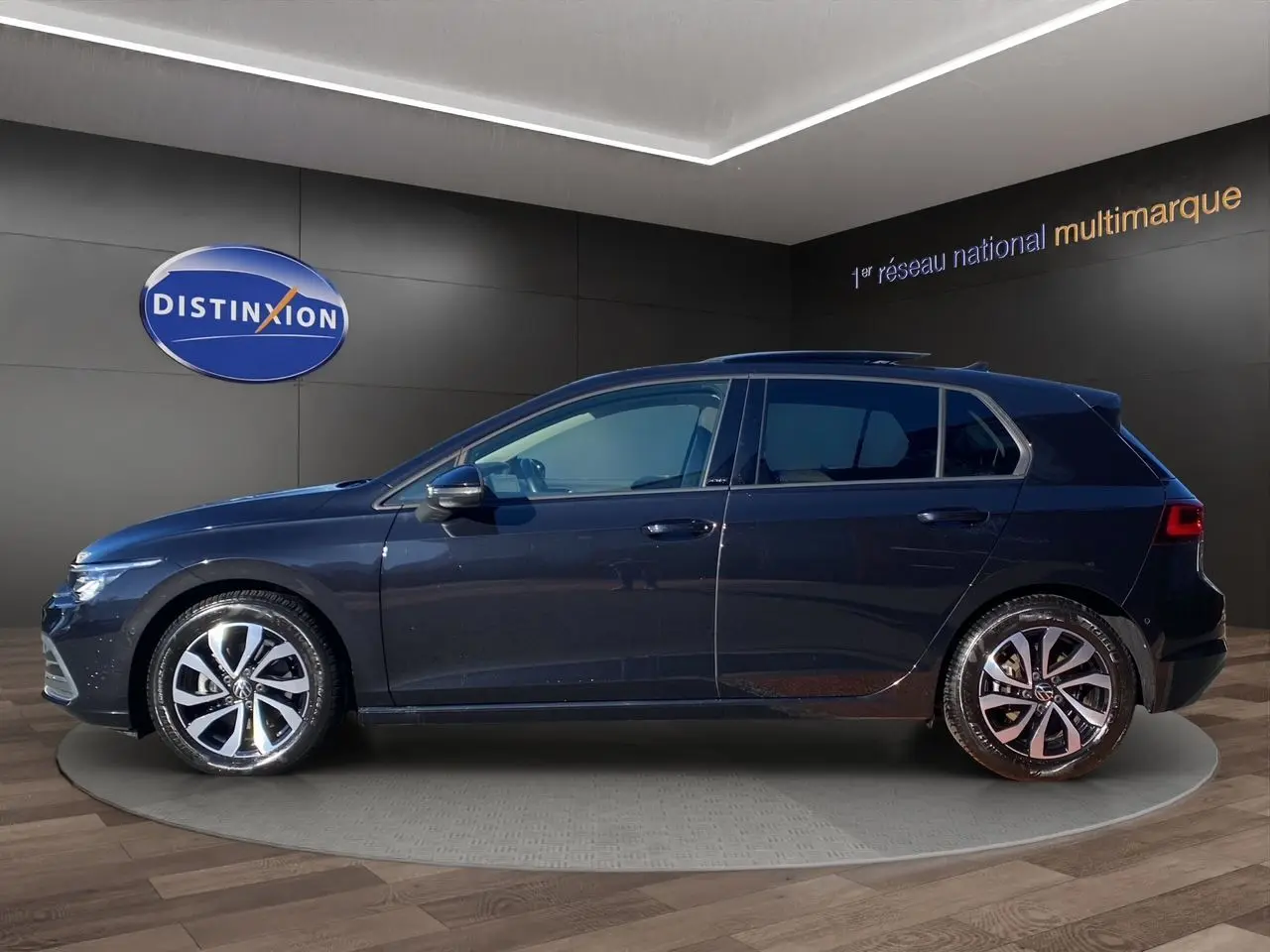 Profil gauche d'une Volkswagen Golf VIII noire nacrée, avec jantes alu 16 pouces et vitres arrière surteintées.