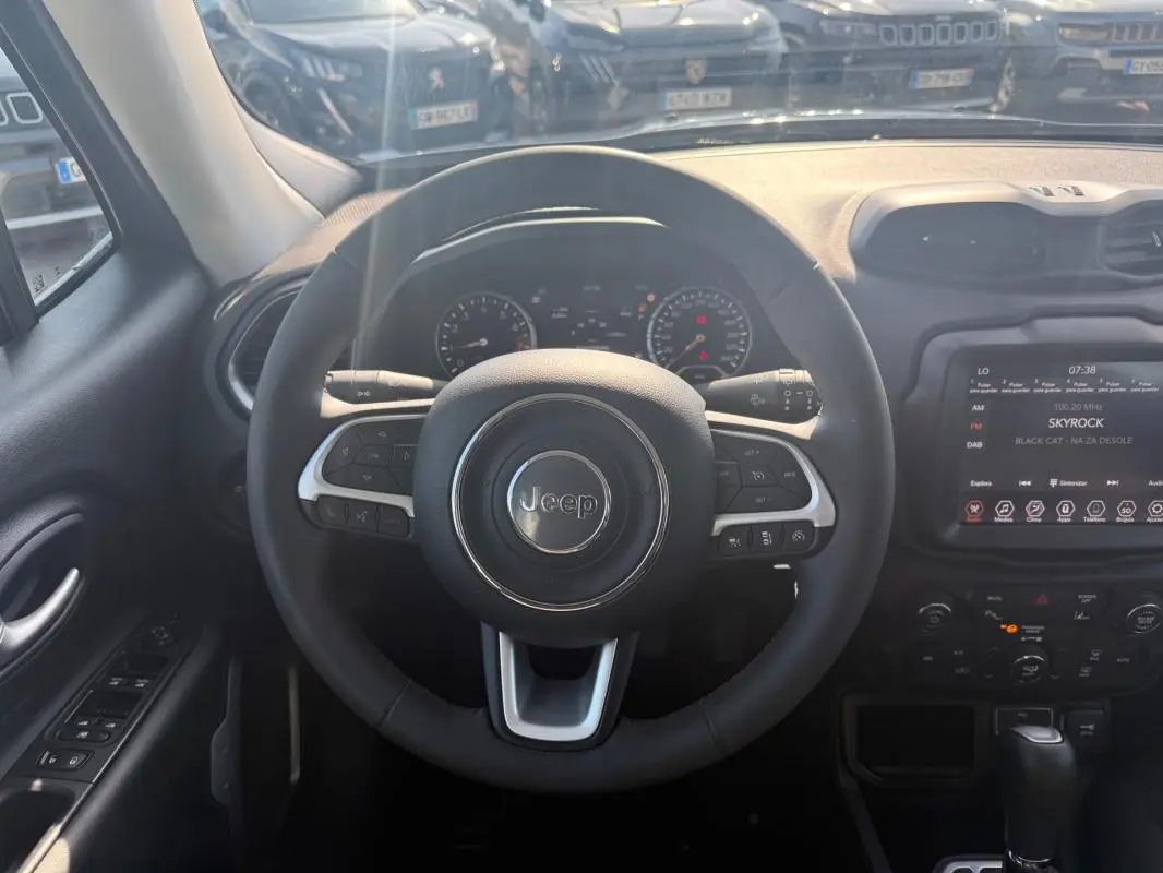 Vue intérieure centrée sur le volant Jeep d'un Renegade 2023, avec écran tactile et commandes au volant visibles.