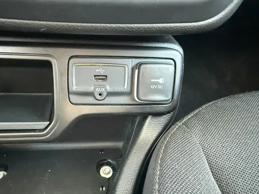 Gros plan sur la prise USB, prise auxiliaire et prise 12V dans l'habitacle noir du Jeep Renegade 2023.