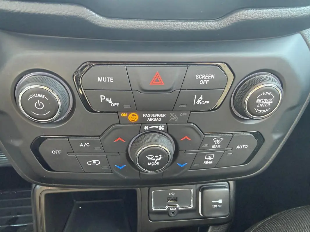 Vue rapprochée du tableau de bord central de la Jeep Renegade 2023, avec commandes climatisation et connectiques USB et 12V.