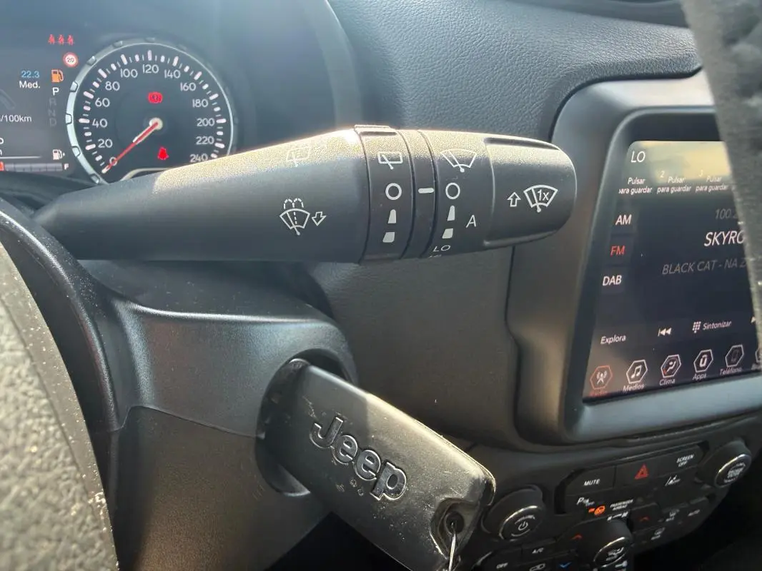 Gros plan sur la commande d’essuie-glace et le tableau de bord noir du Jeep Renegade 2023 avec clé insérée.