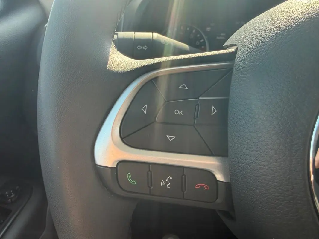 Gros plan sur les commandes du volant noir du Jeep Renegade 2023, avec boutons de navigation et appels.