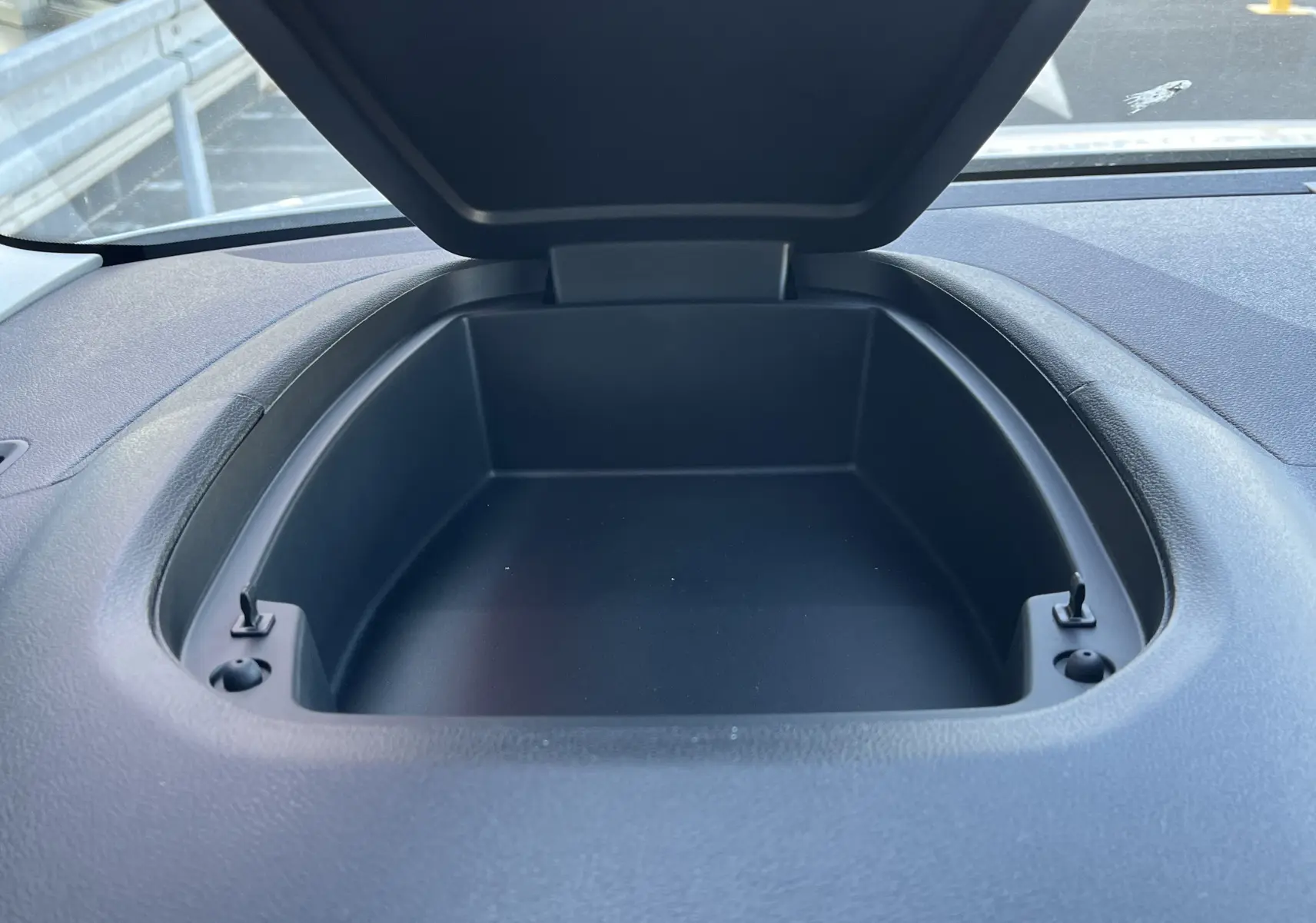 Rangement ouvert sur le tableau de bord du Toyota Proace City blanc glacier, vue intérieure en plongée.