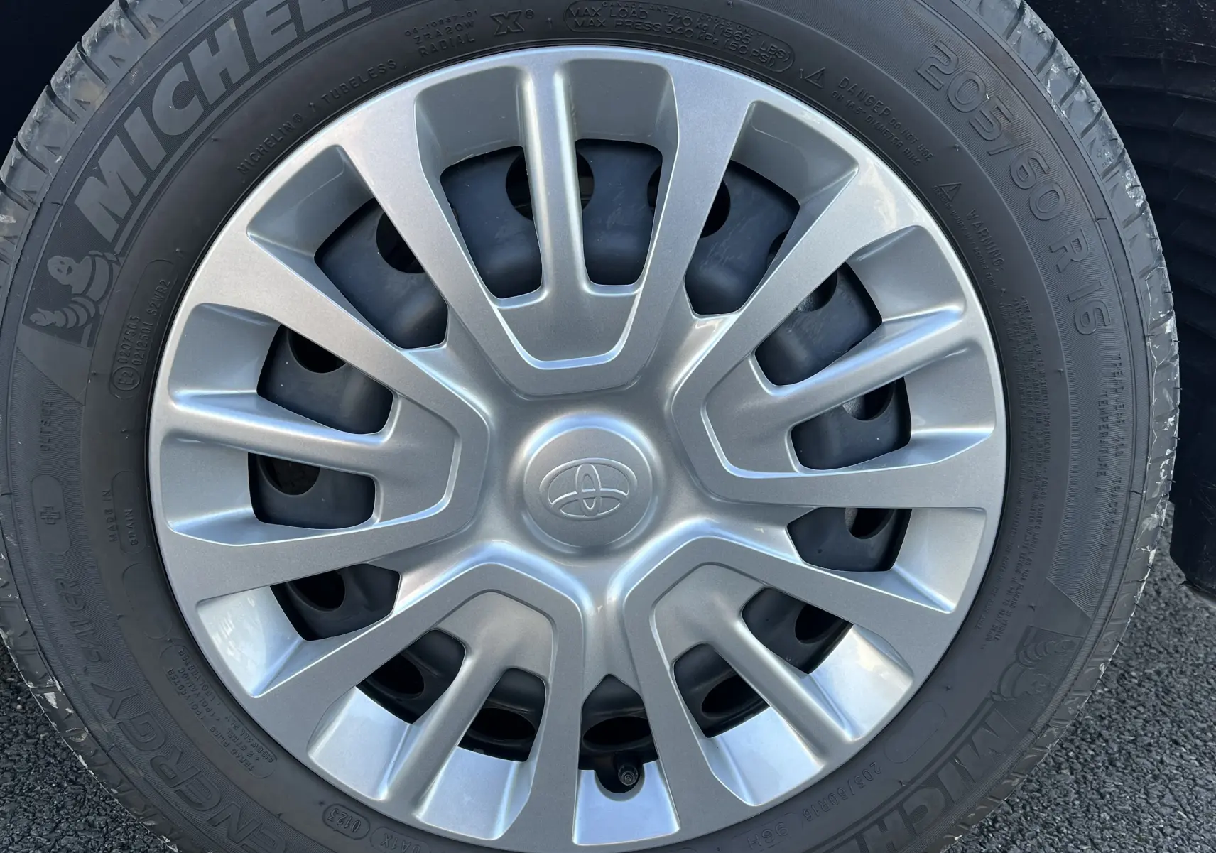 Gros plan sur la roue avec jante argentée et pneu Michelin du Toyota Proace City blanc glacier 2023.