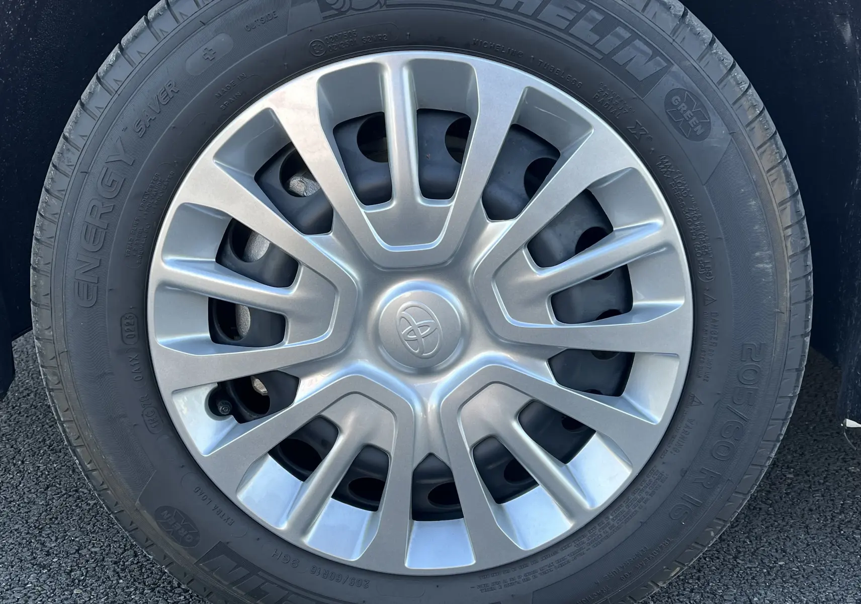 Gros plan sur la roue avant droite d'un Toyota Proace City blanc glacier avec jante en alliage argentée.