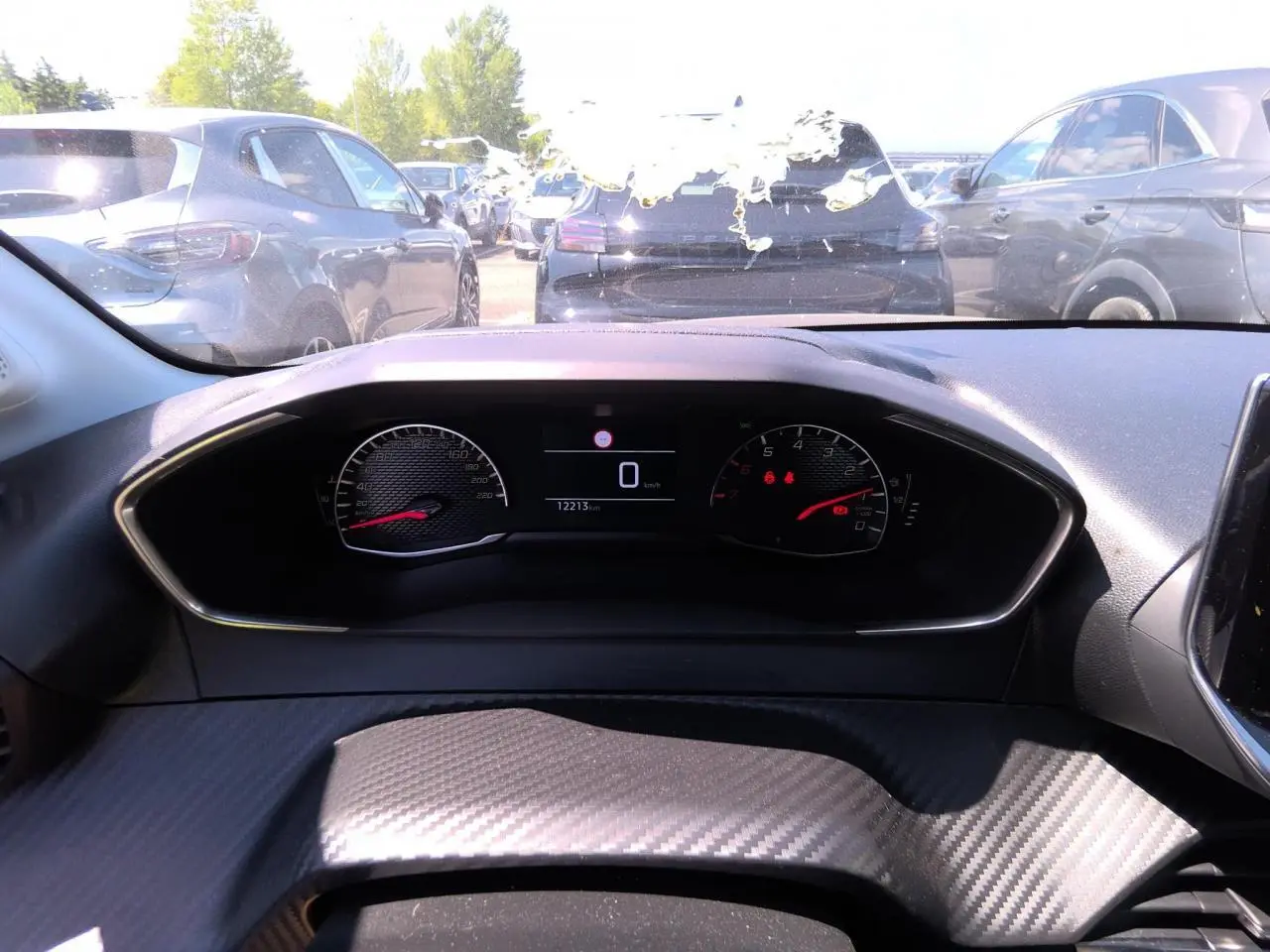 Vue intérieure du tableau de bord de la Peugeot 208 2024 avec compteur digital et volant partiellement visible.