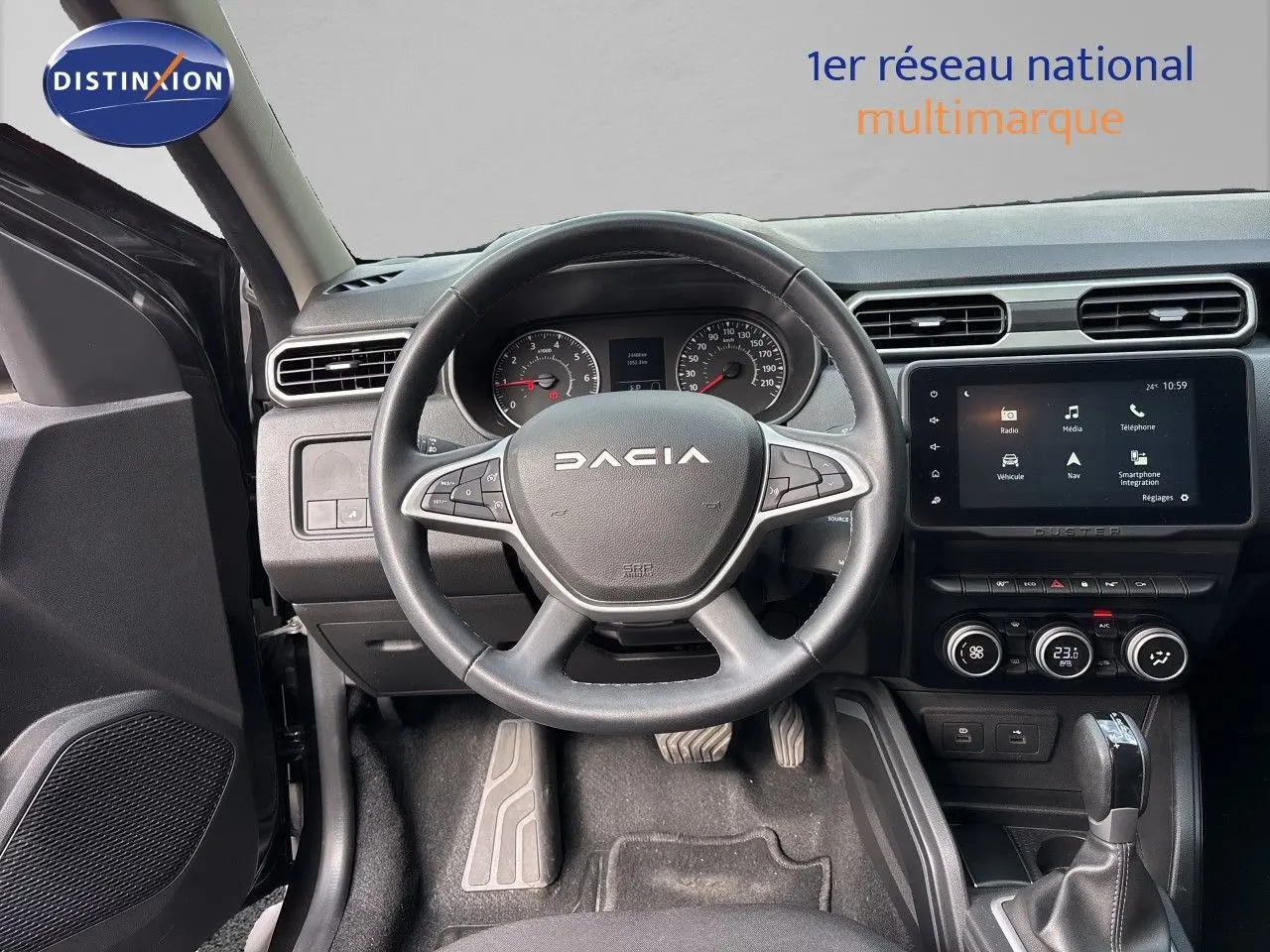 Vue intérieure centrée sur le volant DACIA noir et le tableau de bord avec écran tactile du Duster 2024.