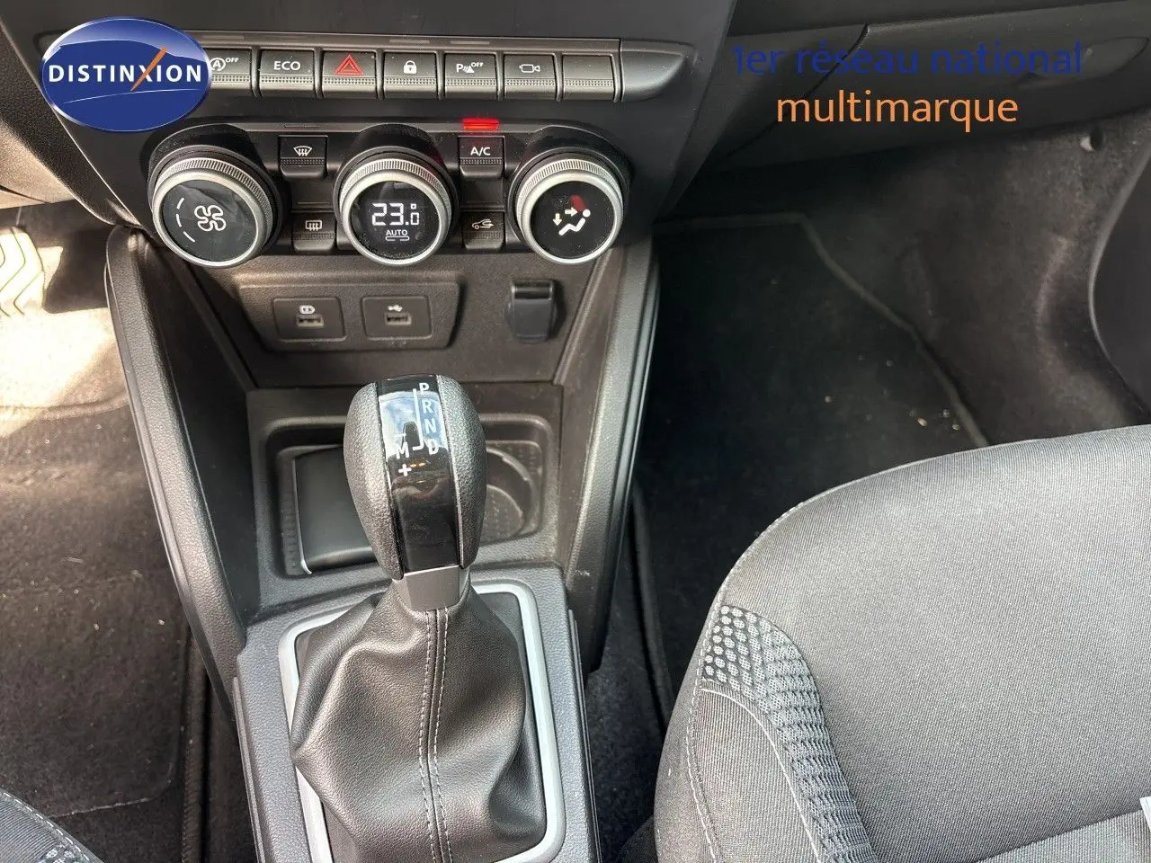 Gros plan sur la console centrale du Dacia Duster noir 2024, avec levier de boîte auto et commandes de climatisation.
