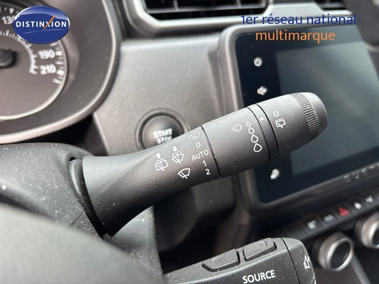Gros plan sur la commande d’essuie-glace du tableau de bord d’un Dacia Duster noir 2024, intérieur visible.