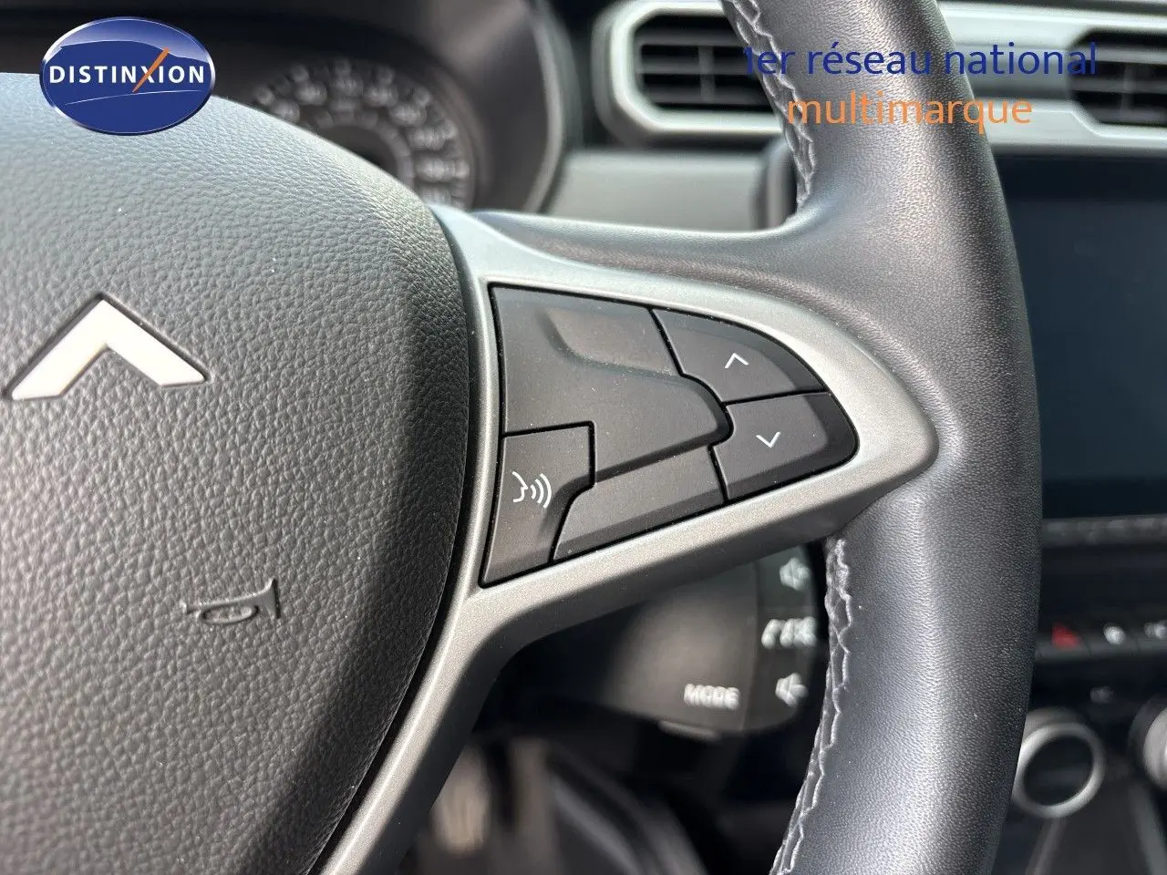 Gros plan sur le volant noir du Dacia Duster 2024, version Journey TCE 150 EDC, avec commandes intégrées côté droit.