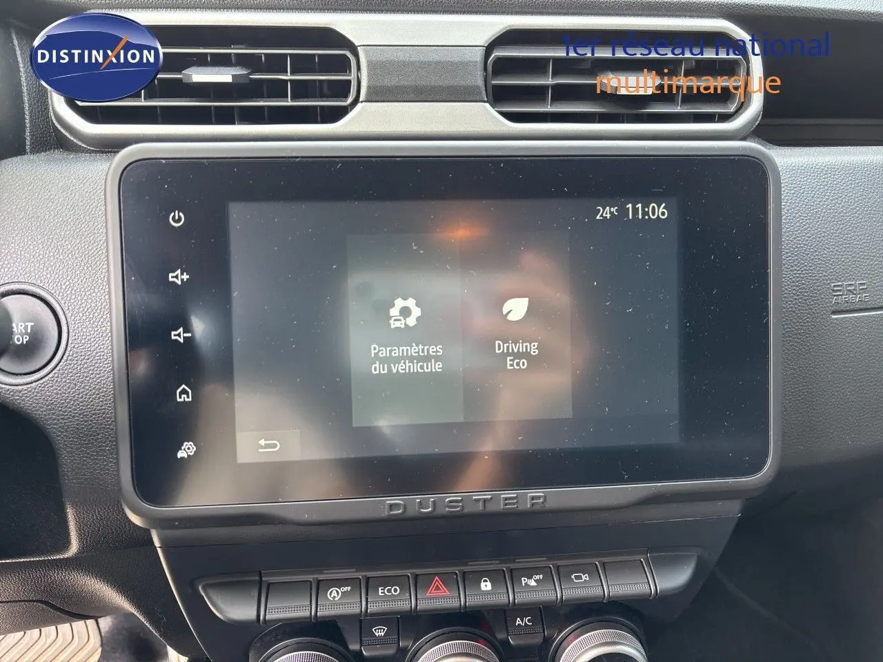 Vue rapprochée de l’écran tactile central et des commandes du tableau de bord du Dacia Duster noir 2024.