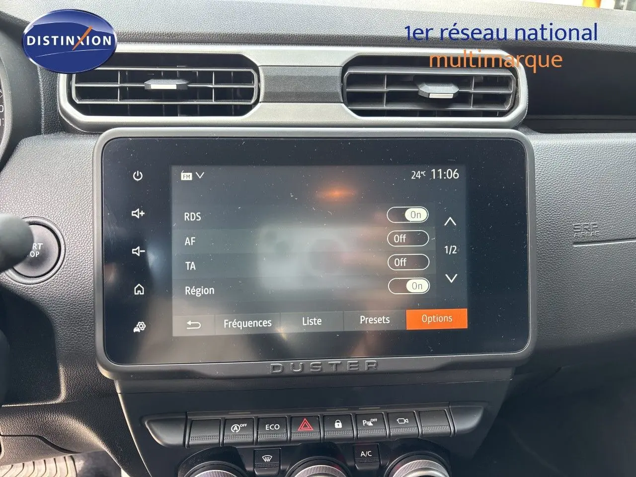 Vue rapprochée de l’écran tactile central du Dacia Duster noir 2024, avec commandes climatisation et boutons fonctionnels visibles.