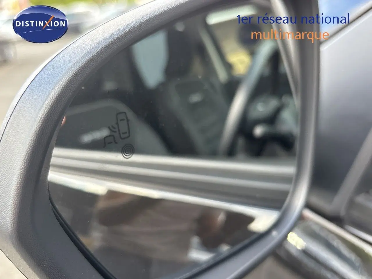 Rétroviseur extérieur gauche du Dacia Duster noir 2024, avec indication d'alerte d'angle mort visible sur le miroir.