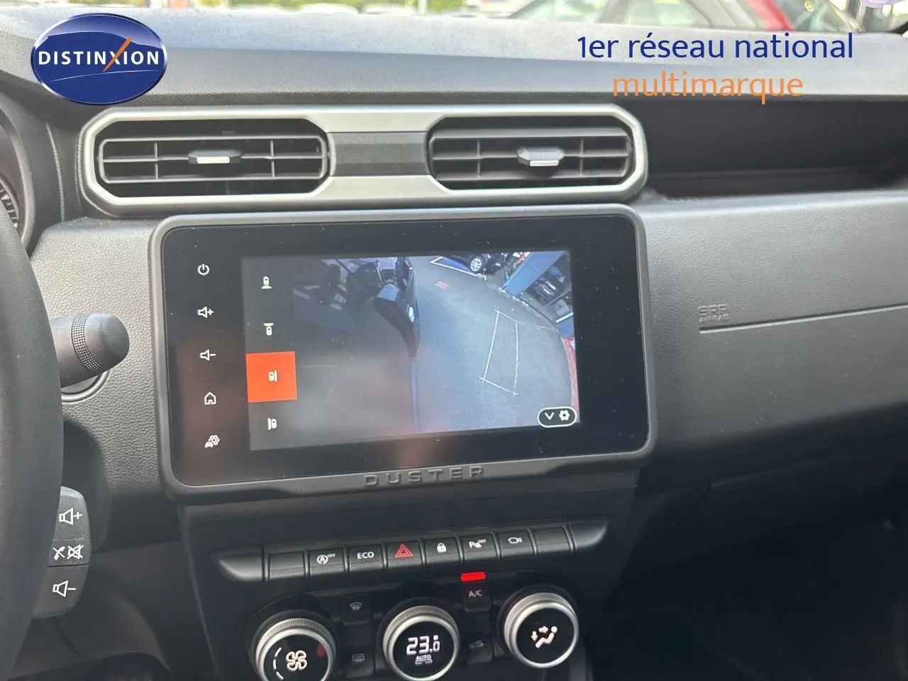 Intérieur du Dacia Duster 2024 noir, vue sur la console centrale avec écran tactile affichant la caméra de recul.