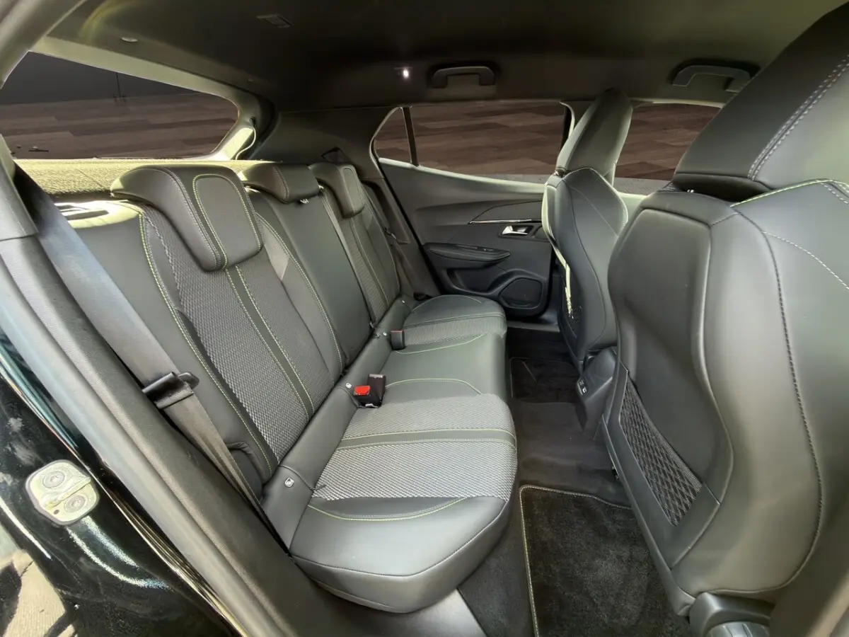 Vue intérieure côté gauche des sièges arrière en cuir noir avec surpiqûres vertes du Peugeot 2008 Hybrid 145 e-DCS6 GT 2026.