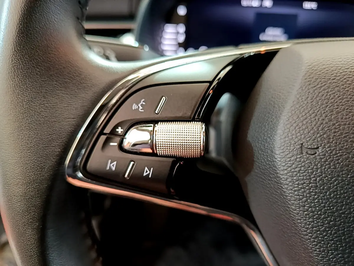 Gros plan sur les commandes du volant cuir noir du Skoda Kamiq 2022, avec molette métallique et boutons multifonctions.