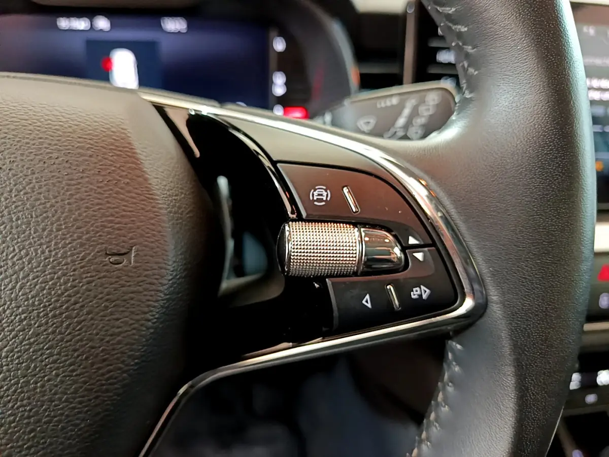 Gros plan sur les commandes du volant cuir côté droit du Skoda Kamiq gris clair 2022 avec boutons multifonctions.