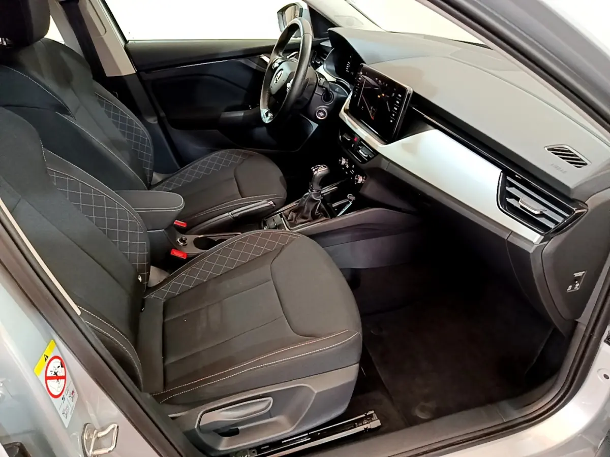 Intérieur avant droit du Skoda Kamiq gris clair 2022, sièges noirs avec surpiqûres et tableau de bord moderne.