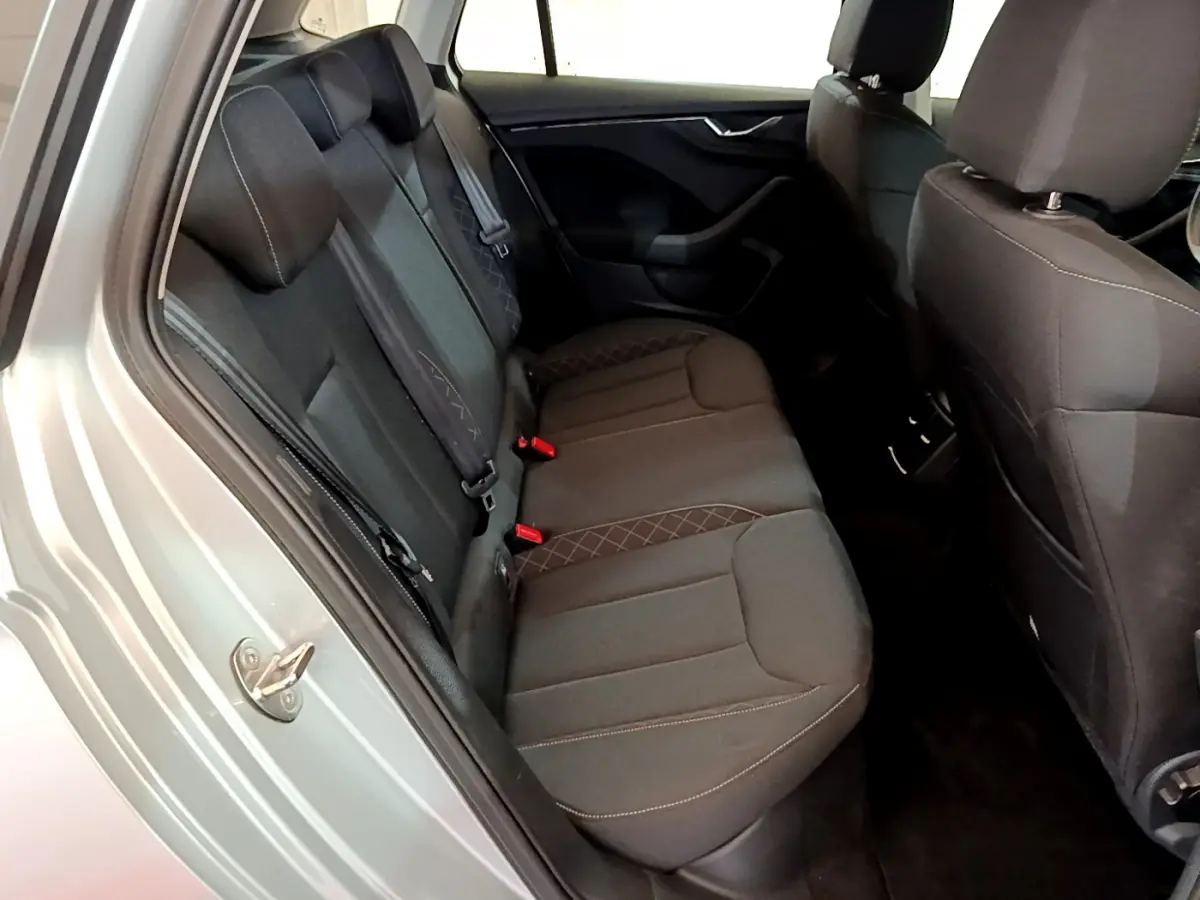 Vue intérieure côté gauche sur la banquette arrière noire avec surpiqûres du Skoda Kamiq gris clair 2022.