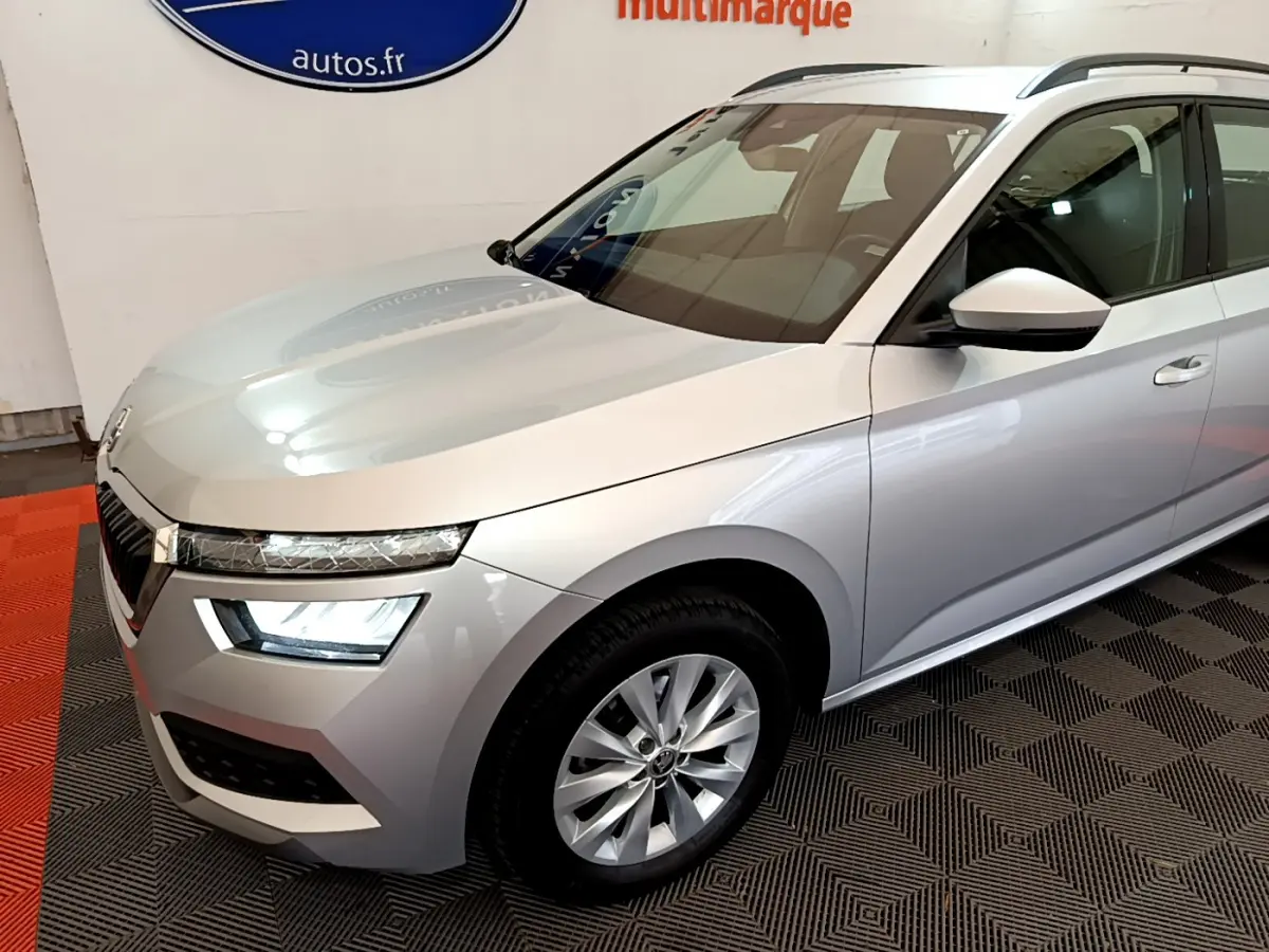 Vue 3/4 avant droit d'un Skoda Kamiq gris clair 2022 avec phares LED et jantes alliage visibles.