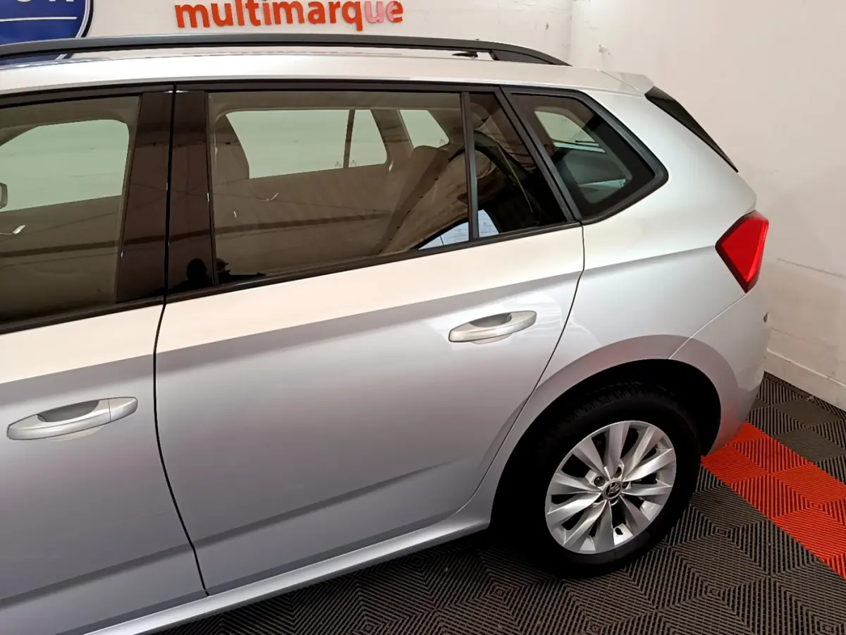 Vue latérale droite du Skoda Kamiq gris clair 2022, mettant en valeur la porte arrière et la roue arrière en jante alliage.