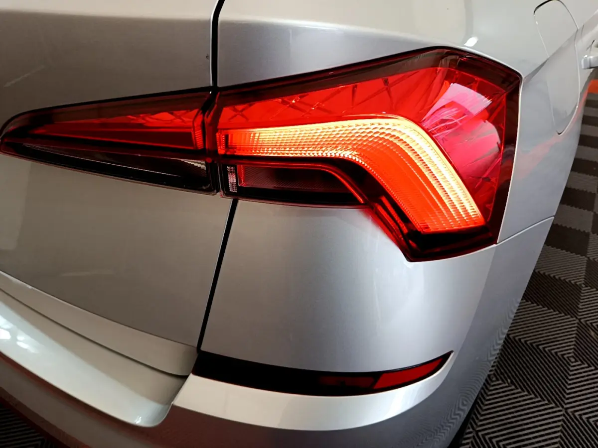 Gros plan sur le feu arrière droit rouge d’un Skoda Kamiq gris clair 2022, avec détails du coffre et pare-chocs.