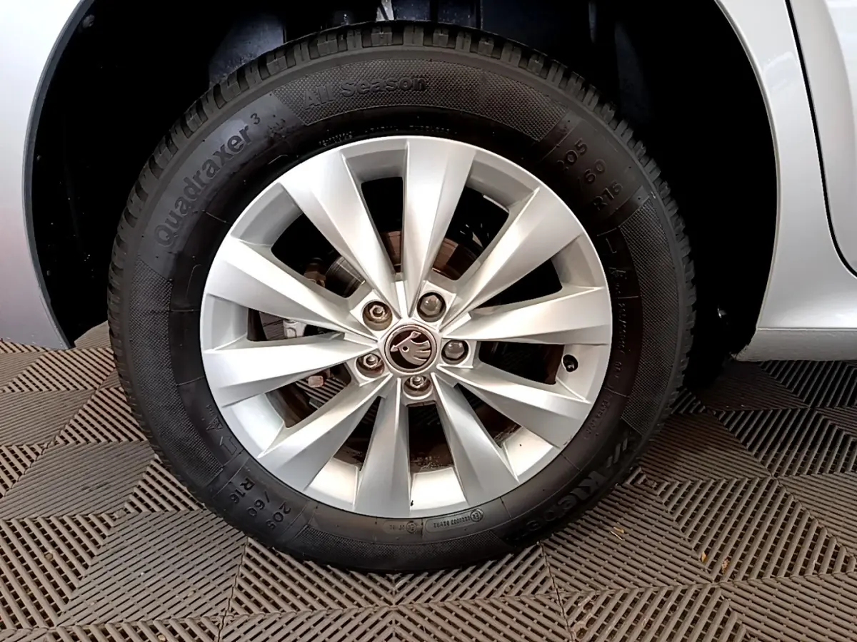 Gros plan sur la roue avant gauche gris clair d'un Skoda Kamiq 2022 avec jante alliage et logo central visible.