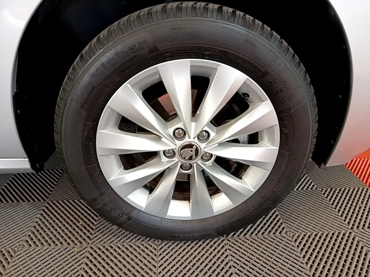 Gros plan sur la roue avant droite gris clair d'un Skoda Kamiq 2022 avec jante alliage et logo central visible.