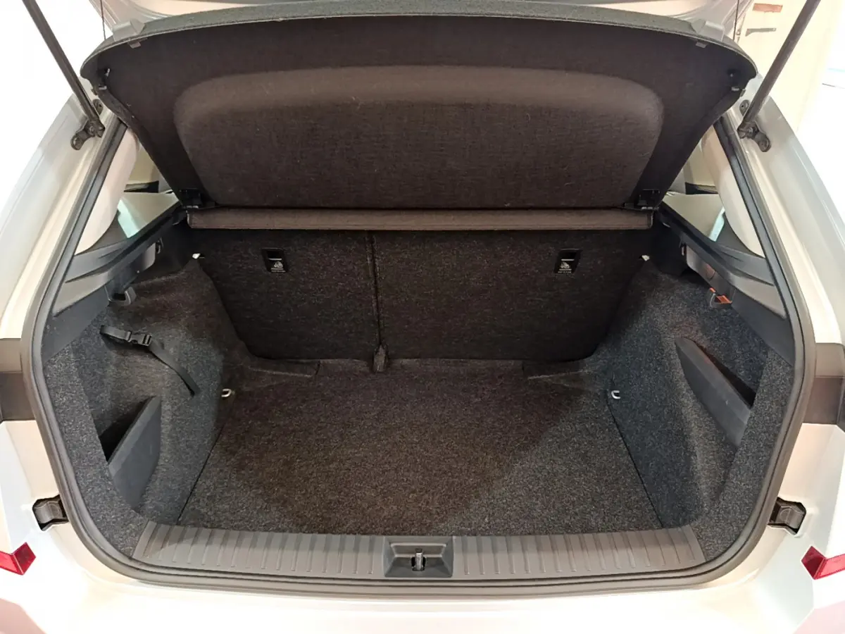 Coffre ouvert vu de l'arrière d'un Skoda Kamiq gris clair, montrant l'espace de chargement et la tablette arrière.