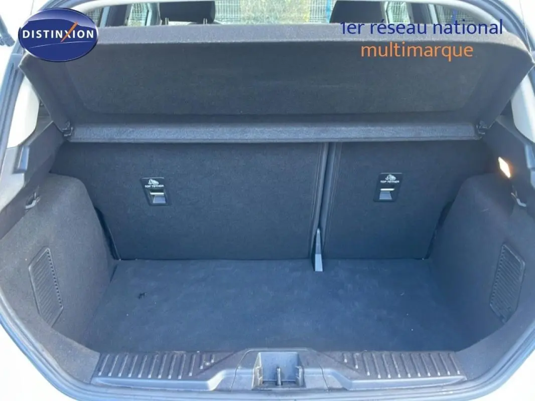 Coffre ouvert vu de l'arrière d'une Ford Fiesta blanche 2020, montrant un espace de chargement propre et vide.