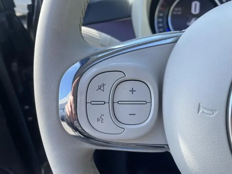 Gros plan sur les commandes de volume et téléphone au volant gris clair de la Fiat 500 1.2 69 cv Club 2019.