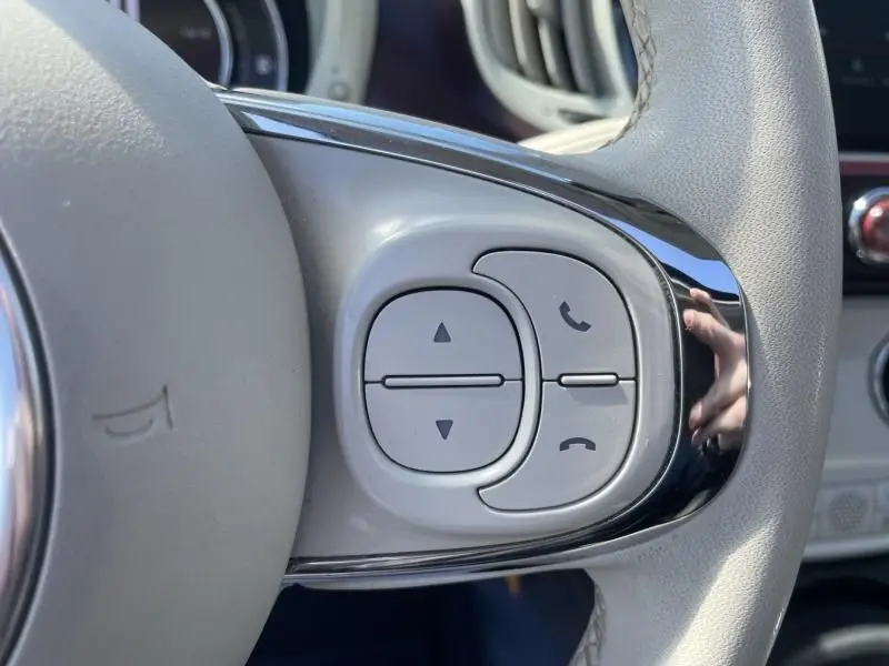 Gros plan sur les commandes grises du volant côté droit d'une Fiat 500 gris foncé, version 1.2 69 cv Club de 2019.