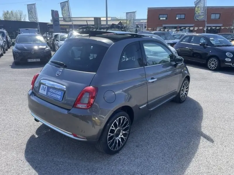 Vue 3/4 arrière droite d'une FIAT 500 gris foncé 2019 avec jantes alliage et toit noir en concession.