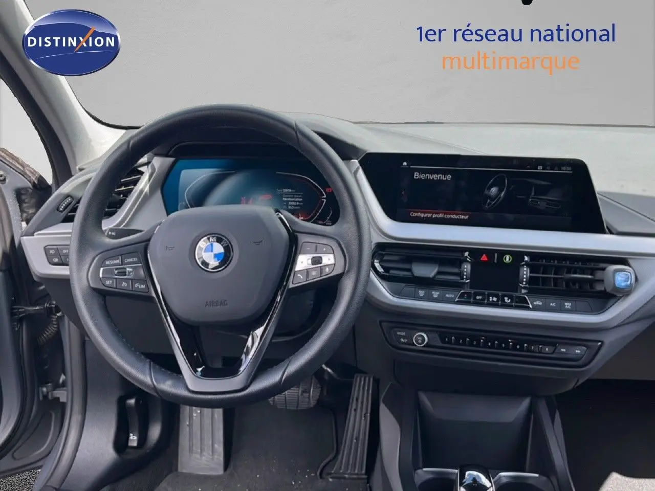 Vue intérieure frontale du tableau de bord et volant cuir noir d'une BMW Série 1 116i 2022 en Frozen Pure Grey.