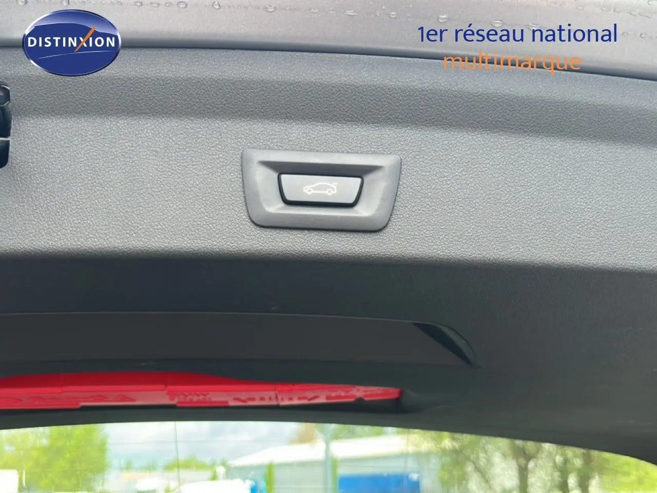 Bouton d'ouverture du coffre sur la garniture intérieure arrière d'une BMW Série 1 116i 2022 couleur Frozen Pure Grey.