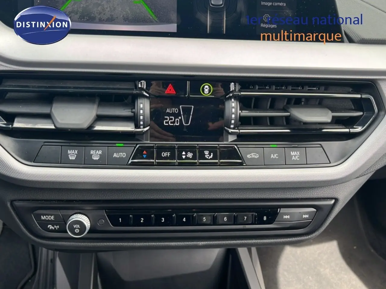 Vue rapprochée du tableau de bord de la BMW Série 1 116i 2022 en gris Frozen Pure, montrant la console de climatisation et les commandes multimédia.