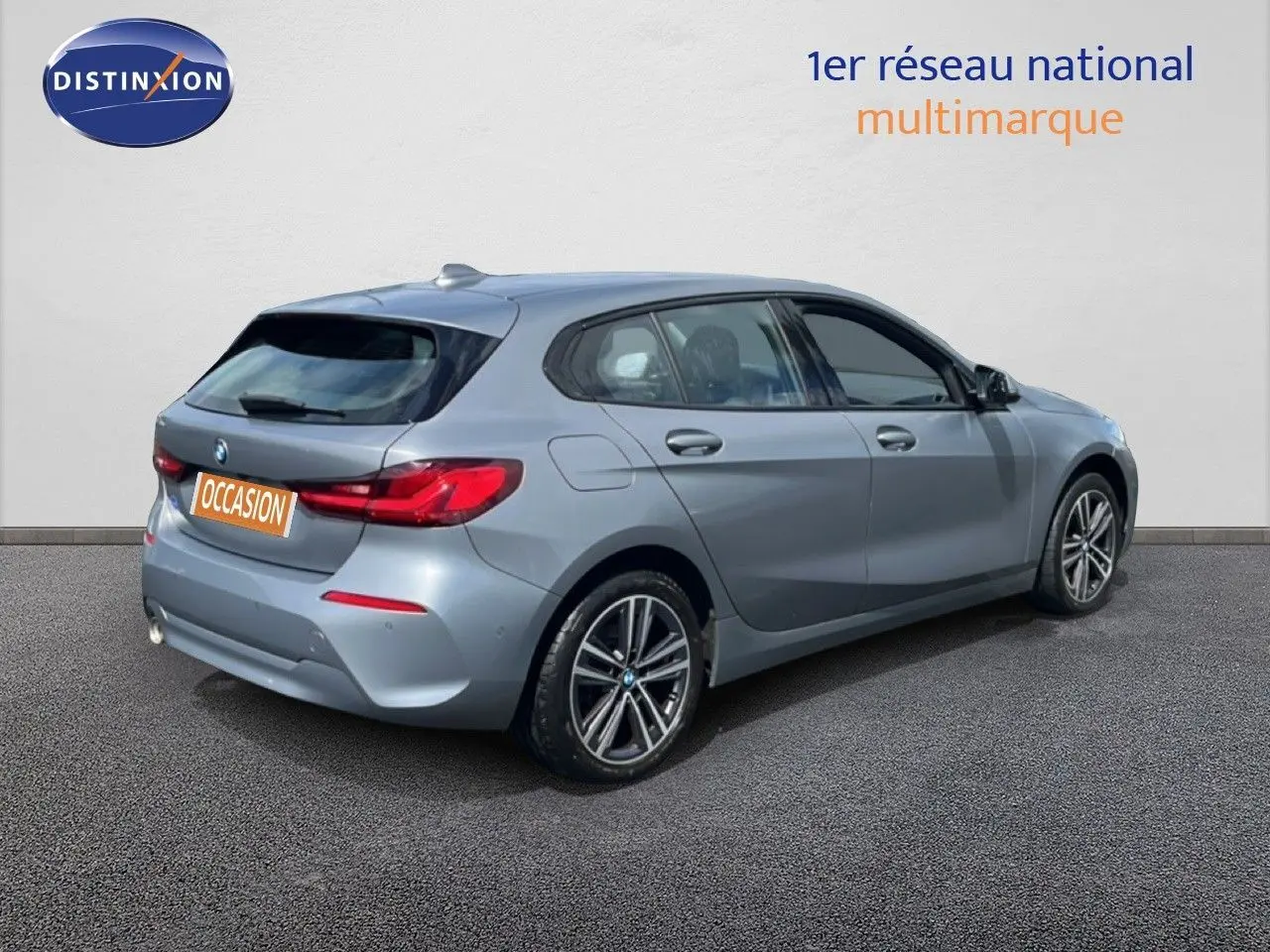 BMW Série 1 116i gris Frozen Pure vue 3/4 arrière droit, avec feux arrière LED et jantes bi-ton 17 pouces.