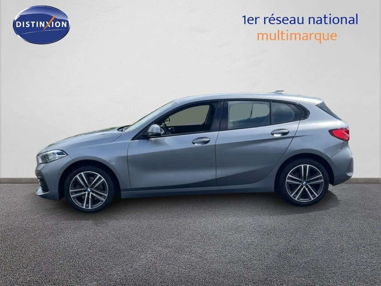 Profil gauche d'une BMW Série 1 116i 2022 en gris Frozen Pure avec jantes alliage bi-ton et vitres teintées.