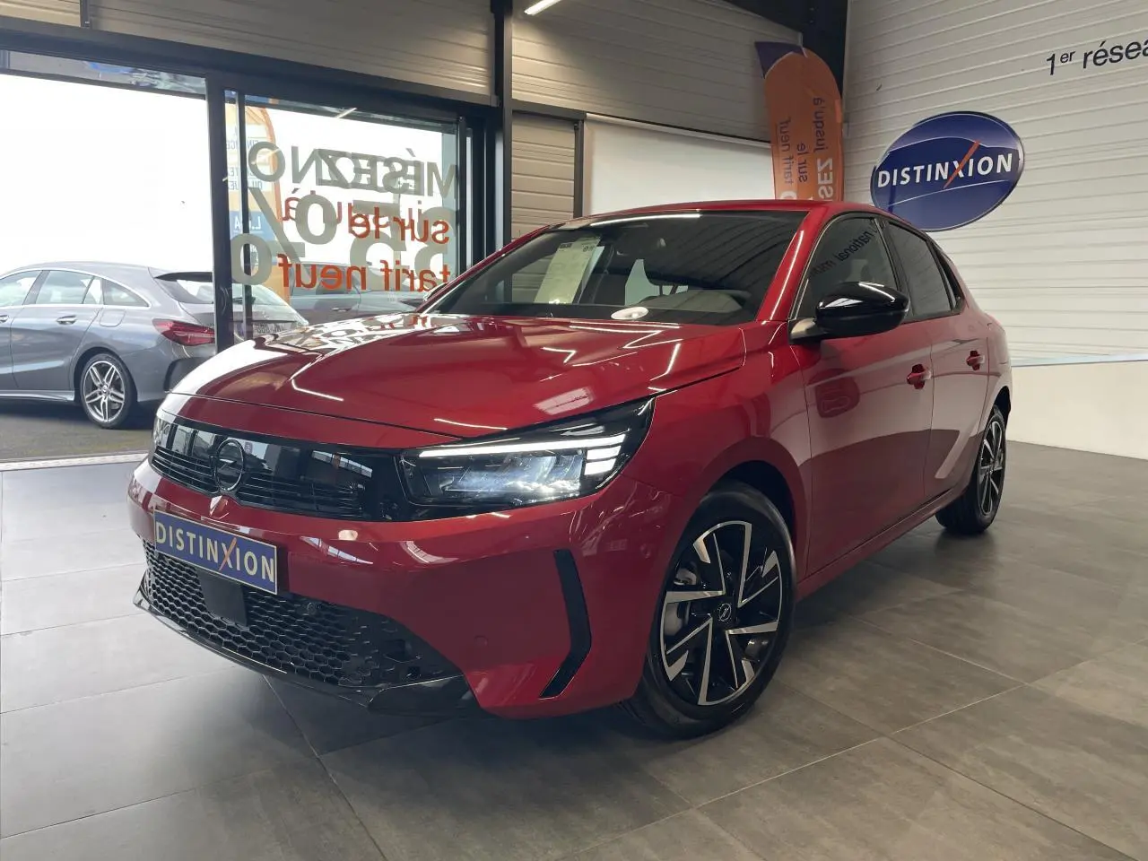 Opel Corsa rouge vue 3/4 avant droit, calandre noire Vizor et jantes alliage 16 pouces diamantées.