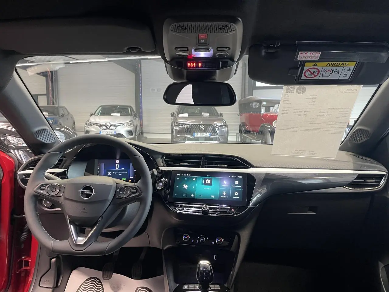 Vue intérieure avant de l’Opel Corsa rouge 2026, avec tableau de bord numérique et écran tactile central 10 pouces.