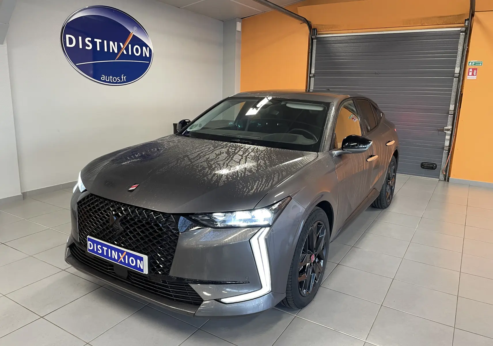 DS4 gris platinium vue 3/4 avant droit en intérieur, avec calandre noire et jantes alliage 19'' Minneapolis.