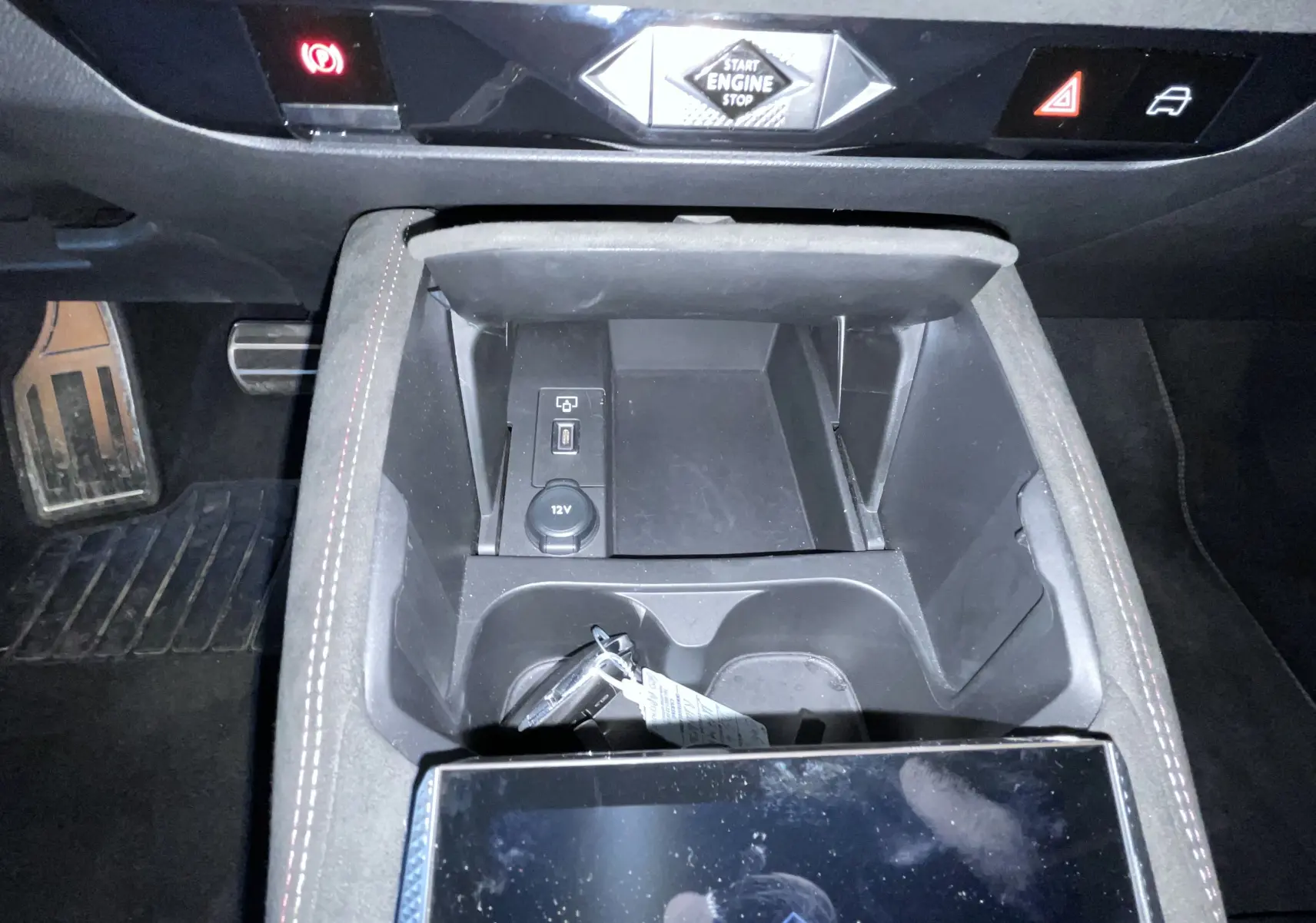 Vue rapprochée de la console centrale du DS4 2024 gris platinium, avec bouton Start Engine Stop et prise 12V visible.