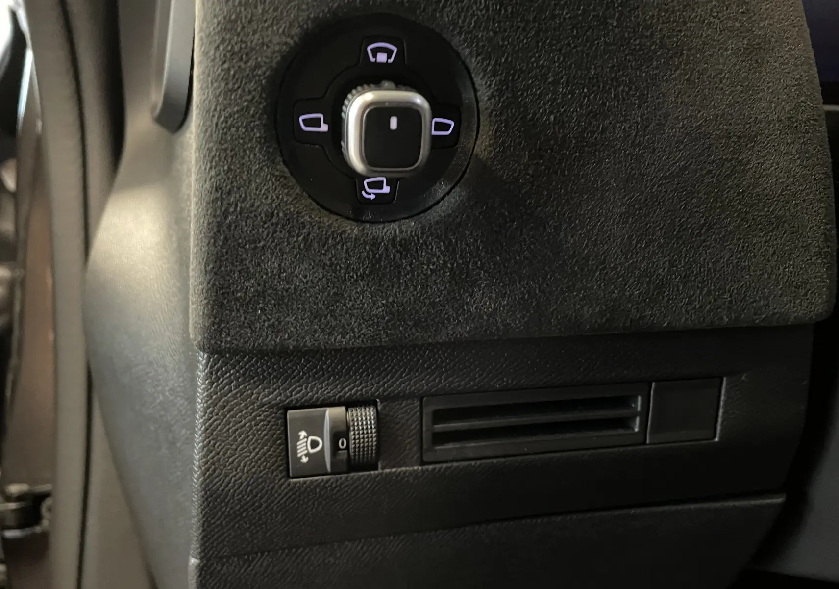 Gros plan sur le panneau de commande des rétroviseurs et réglage des phares dans l'habitacle du DS4 gris platinium.