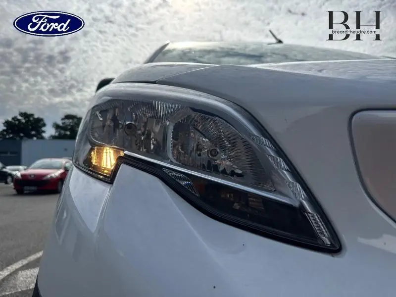 Gros plan sur le phare avant droit du Peugeot Expert Fourgon blanc Banquise, avec clignotant allumé.