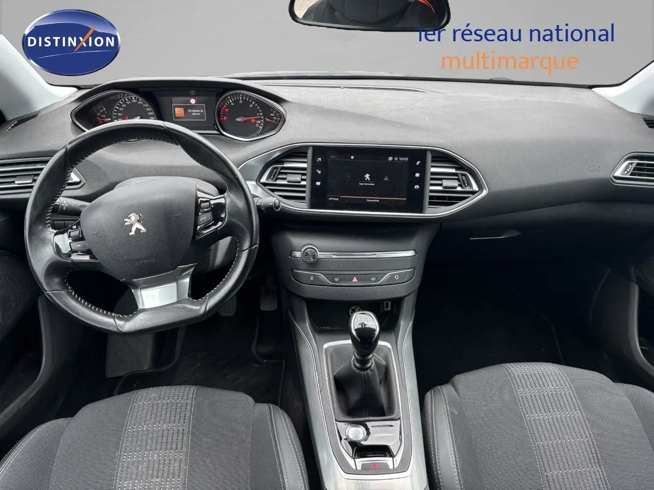Vue intérieure avant de la Peugeot 308 2020, tableau de bord et volant noir avec levier de vitesse manuel.